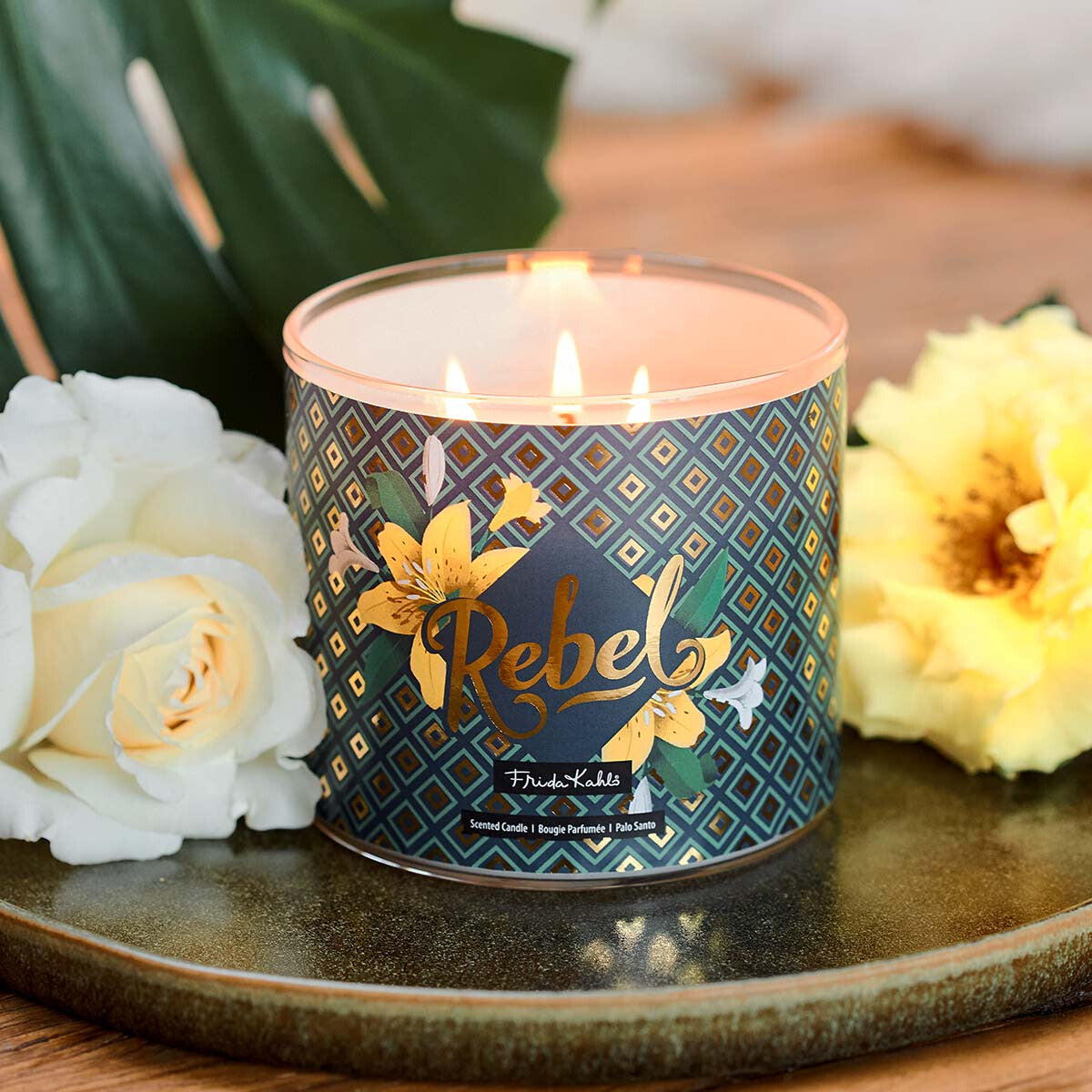Frida Kahlo Duftkerze ‚Rebel‘ (400g) – Moodbild der offiziellen Lizenzkerze ohne Deckel und mit Blick auf die drei Baumwolldochte. Wellness-Duftkerze im Glas, perfekt als Geschenk für Freundinnen.