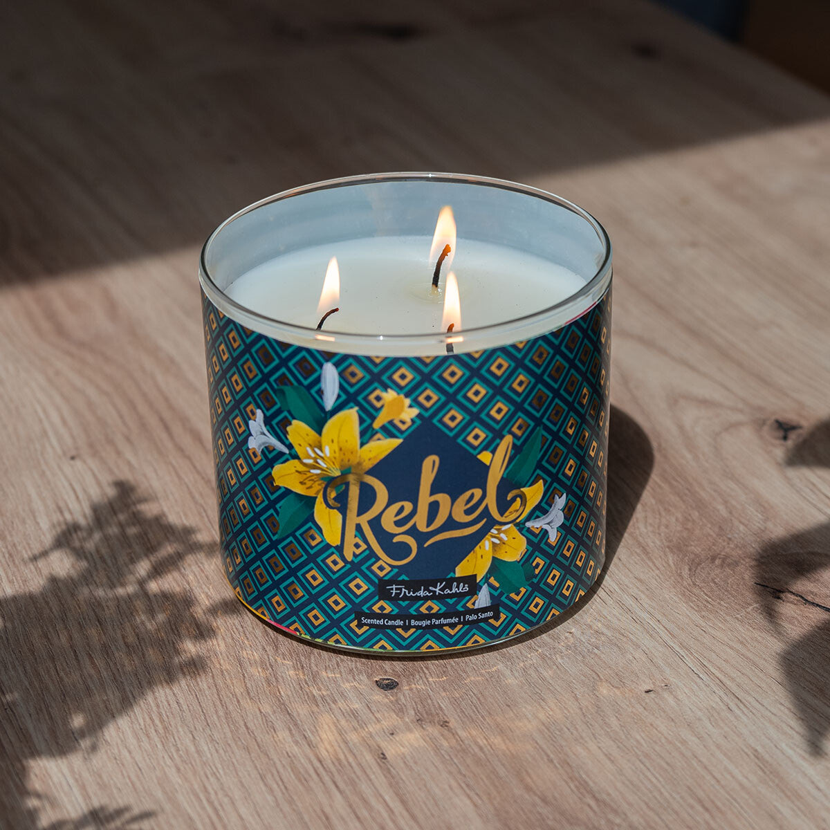 Frida Kahlo Duftkerze ‚Rebel‘ (400g) – Moodbild der offiziellen Lizenzkerze ohne Deckel und mit Blick drei brennende Baumwolldochte. Wellness-Duftkerze im Glas, perfekt als Geschenk oder Deko.