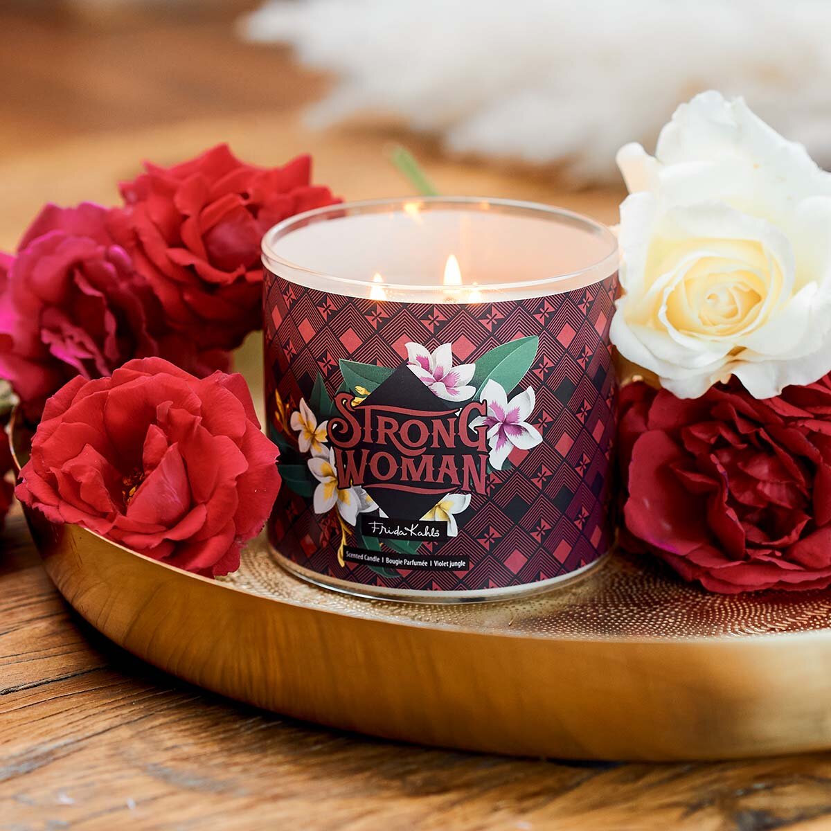 Frida Kahlo Duftkerze ‚Strong Woman‘ (400g) – Moodbild der offiziellen Lizenzkerze ohne Deckel und mit Blick auf die drei brennenden Baumwolldochte. Wellness-Duftkerze im Glas, perfekt als Geschenk für Frauen.