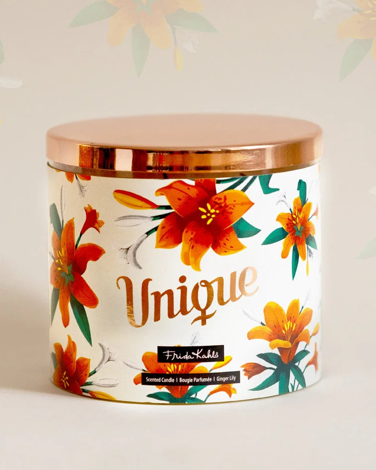 Frida Kahlo Duftkerze ‚Unique‘ (400g) – Moodbild der offiziellen Lizenzkerze im blumigen Design. Die kunstvoll verzierte Kerze steht frontal auf einem weißen Untergrund – dekoratives Wohnaccessoire und ideale Geschenkidee für unter 20 € für Duftkerzen-Liebhaber.
