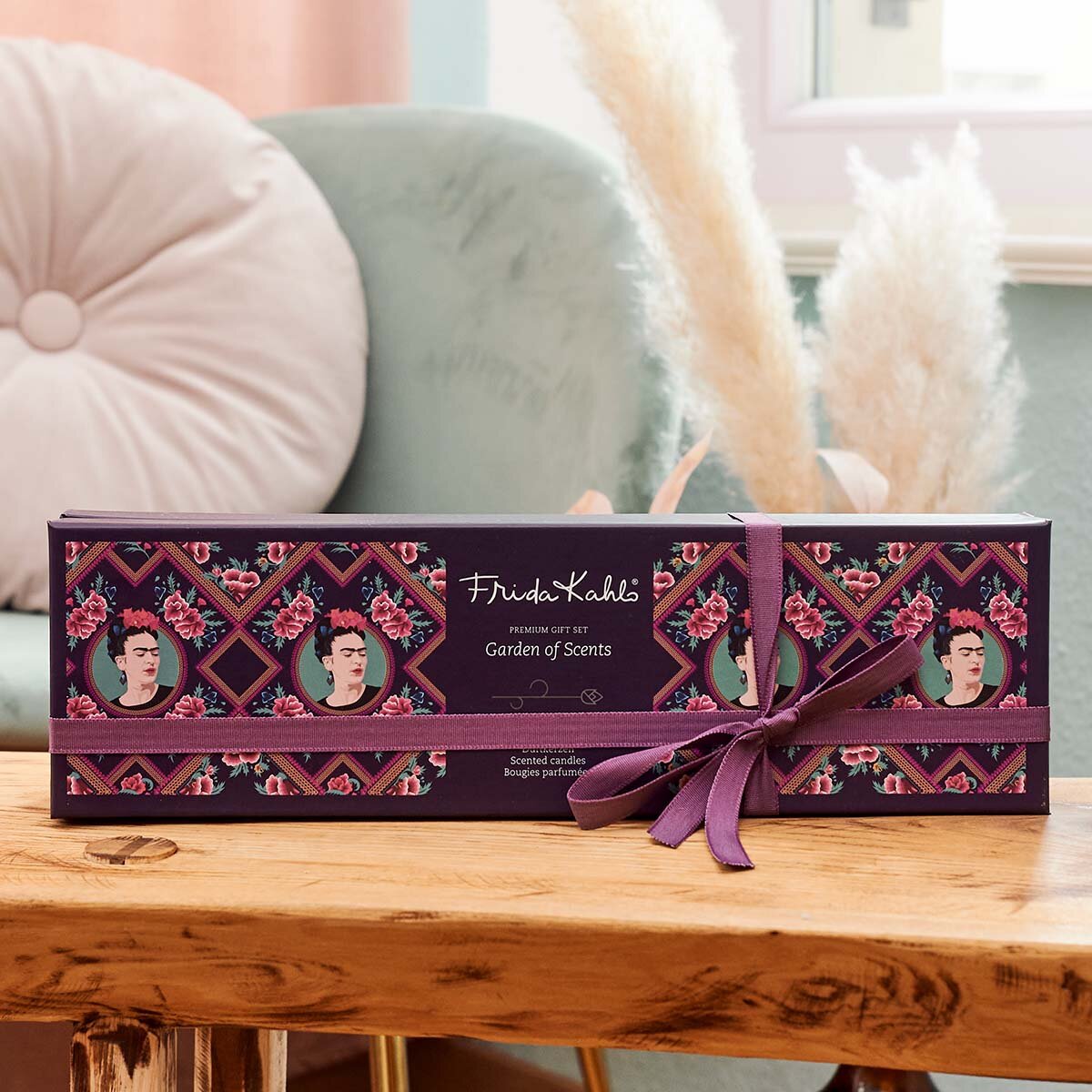 Frida Kahlo Geschenkeset ‚Garden of Scents‘ (5x45 g) - Verpackter Geschenkkarton des Frida Kahlo Sets ‚Garden of Scents‘ auf einem Holztisch. Im Hintergrund sieht man ein grünes Sofa. Das Geschenkeset sieht sehr hochwertig aus.