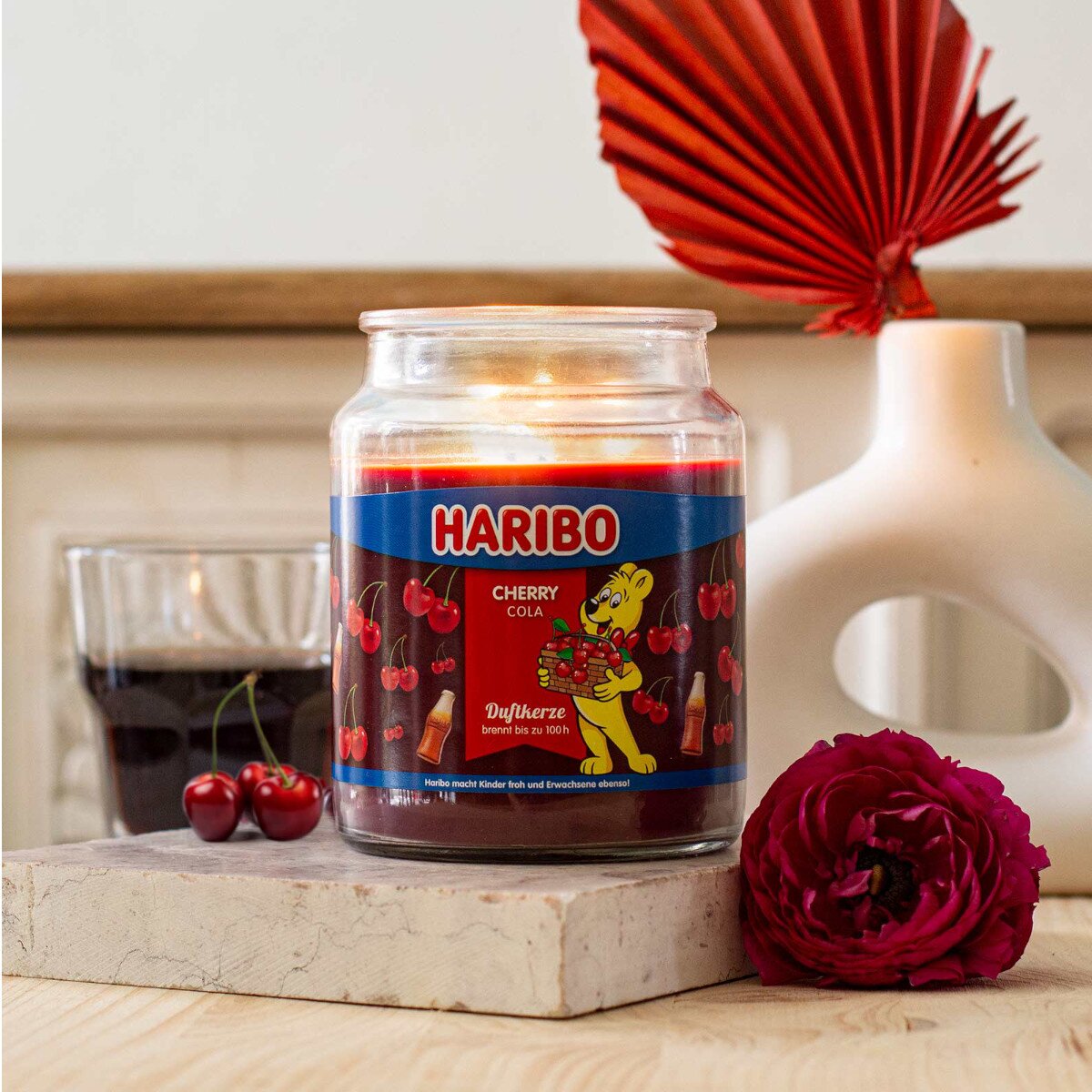 Moodbild der Haribo XXL-Duftkerze ‚Cherry Cola‘ (510g) – offizielle Lizenzkerze mit erfrischendem Duft. Hochwertiges Stimmungslicht und kreative Geschenkidee für Groß und Klein.