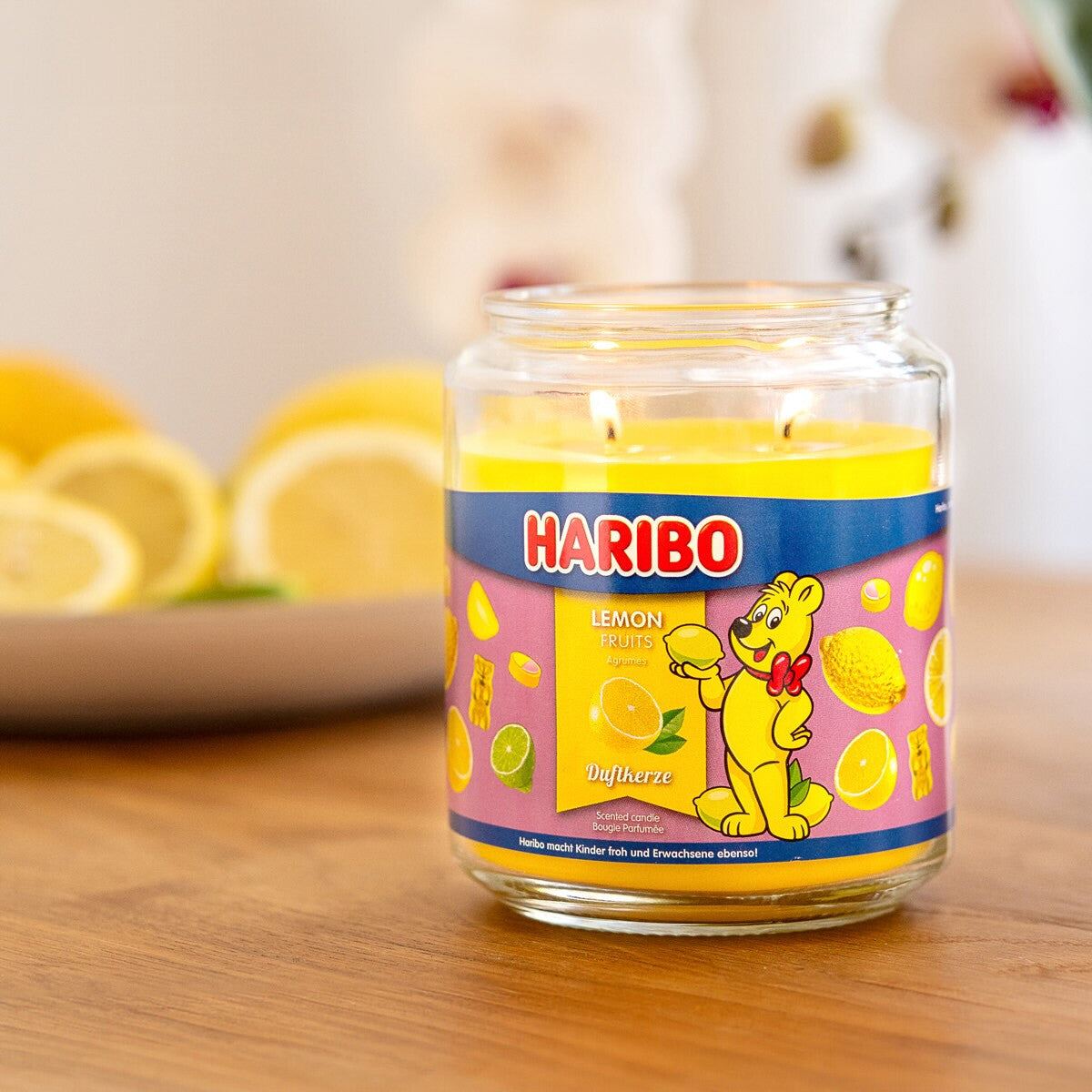 Moodbild der Haribo XXL-Duftkerze ‚Lemon Fruits‘ (510g) – offizielle Lizenzkerze mit erfrischendem Duft (Zitrone, Limette & Grapefruit). Sommerliches Design und der Funktion, dass der Duft Insekten vertreibt.