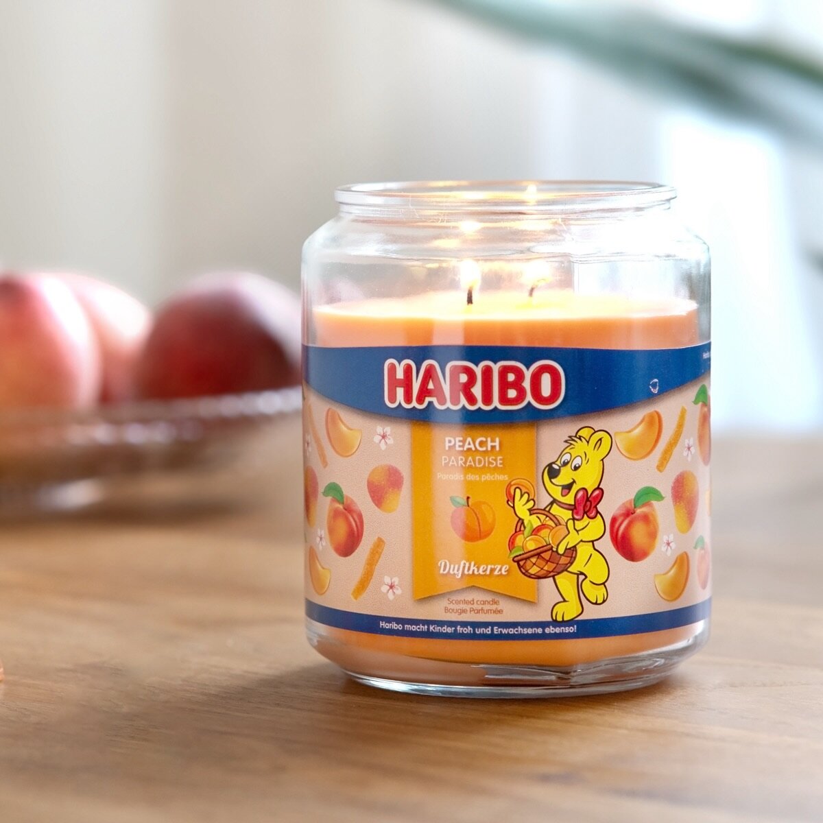 Moodbild der Haribo XXL-Duftkerze ‚Peach Paradise‘ (510g) – offizielle Lizenzkerze mit sommerlichem Duft.  Angenehmer Duft, lange Brenndauer und kreative Geschenkidee.