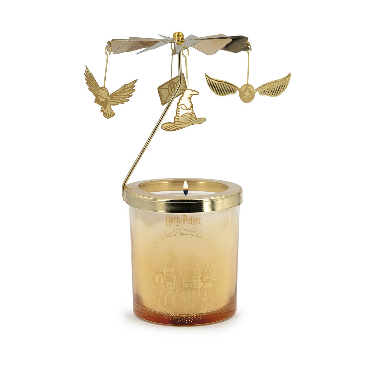 Brennende Harry Potter Duftkerze in einem goldenen Glas mit Hogwarts-Silhouette. Obenauf sitzt ein rotierendes goldenes Karussell mit magischen Anhängern: Hedwig, der Sprechende Hut, ein Hogwarts-Brief und der Goldene Schnatz.