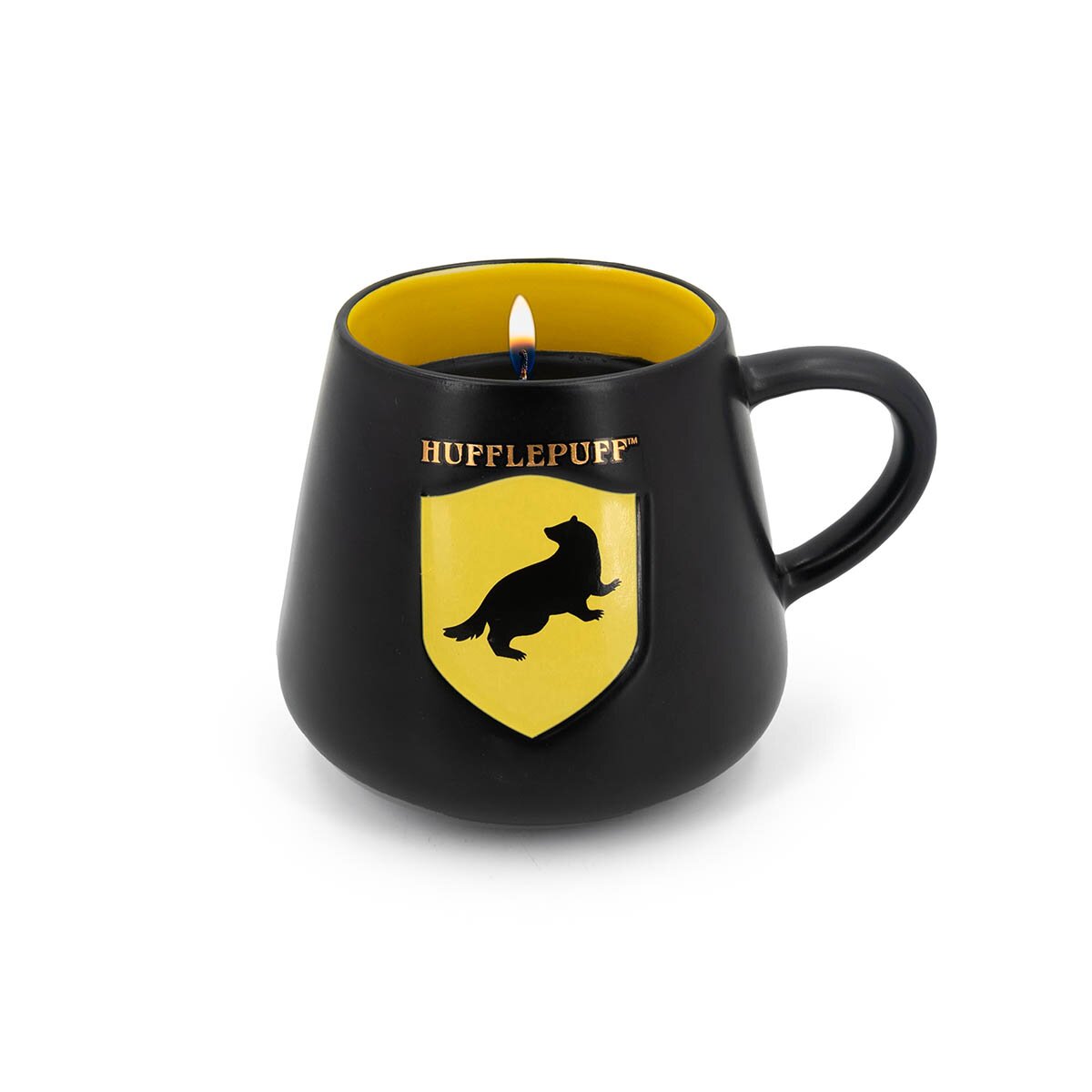 Harry Potter-Duftkerze Hufflepuff (275g) in schwarz-gelber Keramiktasse mit goldenem Schriftzug und Dachs-Wappen, brennender Docht und schmelzendes Wachs.
