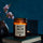 Moodbild: Handgemachte ‚Best Mom ever‘ Duftkerze von mad candle aus Sojawachs mit beschriftetem Etikett – dekoriert auf einem Buch mit einem schwarzen Teelichhalter und einer Vase im Hintergrund. Edles Geschenk für besondere Anlässe oder stilvolle Home-Deko.