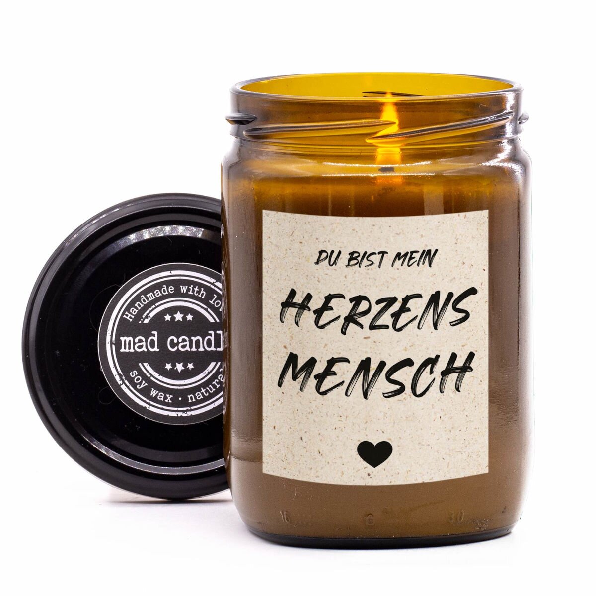 mad candle Duftkerze ‚Du bist mein Herzensmensch‘ mit geöffnetem Deckel und einem brennendem Docht, vegane Duftkerze aus Sojawachs. Perfekt als Geschenk für besondere Menschen.