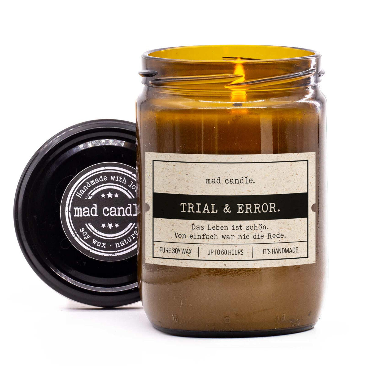 mad candle Duftkerze ‚Trail & Error.‘ – vegane Sojawachs-Kerze mit geöffnetem Deckel & brennendem Docht. Ideal als Geschenk für motivierende Momente. Handgemachte Wellness-Duftkerze für Yoga, Meditation & Selfcare-Rituale zu Hause.