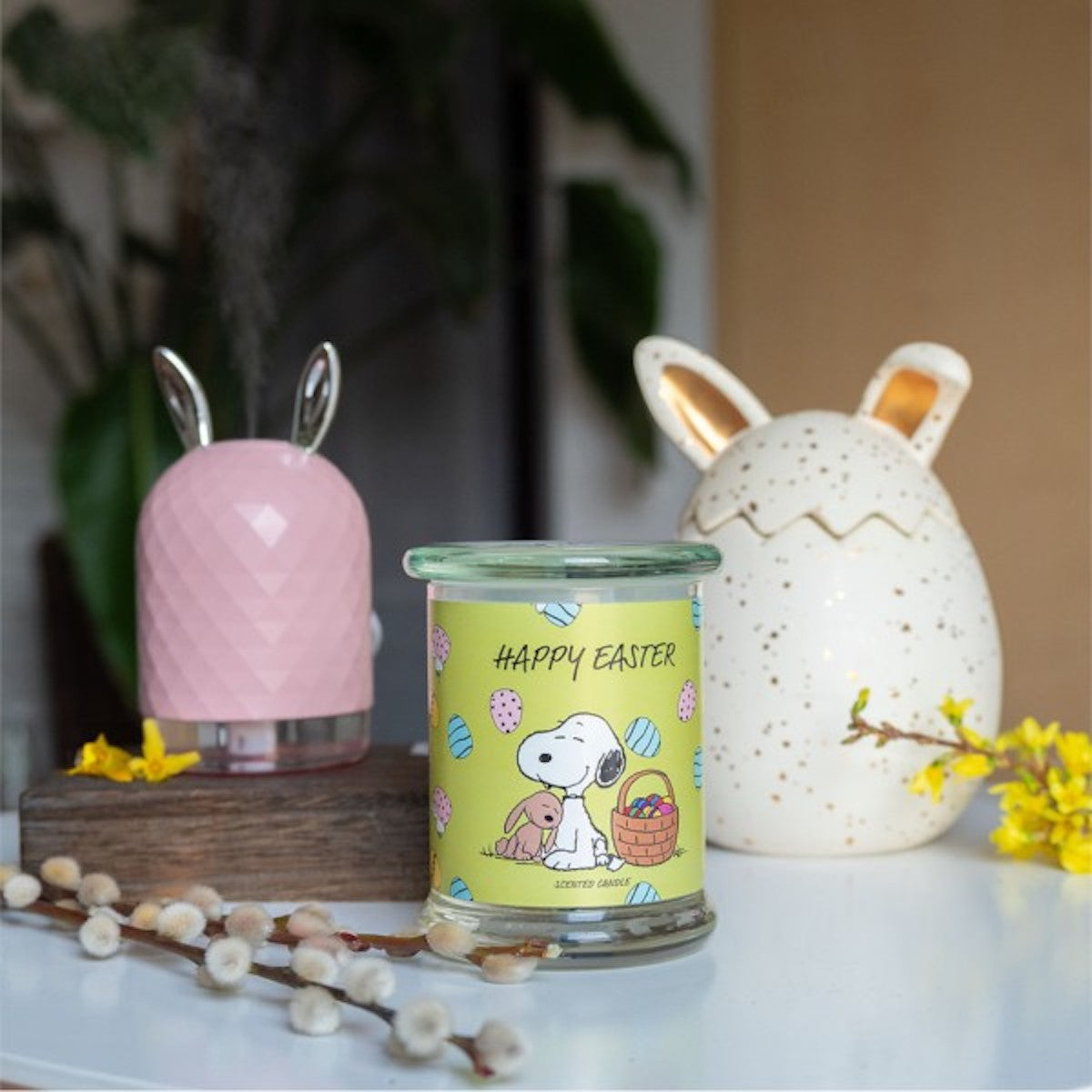 Peanuts Duftkerze ‚Happy Easter‘ (250g) – Moodbild der offiziellen Lizenzkerze mit Frühlings Dekoration – dekorative Duftkerze im Glas mit Snoopy und Osterhasen Motiv für gemütliche Osterstimmung.
