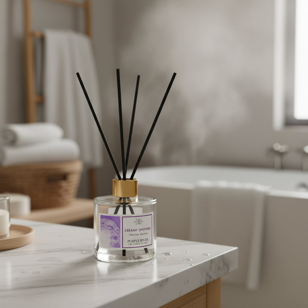 Purple River Raumduft (100 ml) mit schwarzen Schilfstäbchen und goldener Kappe in einem Badezimmer mit heißer Badewanne, weißen Handtüchern und dekorativen Accessoires; hochwertiger Duft mit bis zu 6 Wochen Duftdauer, ideal als stilvolle Dekoration und luxuriöses Wellness-Geschenk, gefertigt in Deutschland.